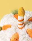 Close-up of a plush toy with orange and white striped legs on a yellow background