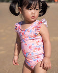Toddler in pink swimsuit at the beach