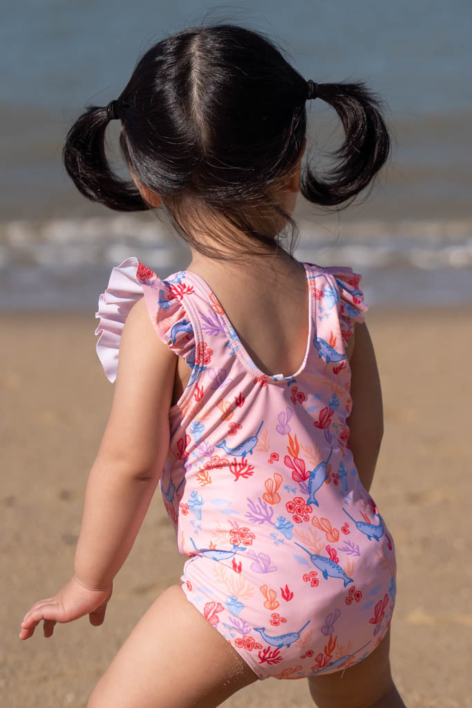 Girl in pink swimsuit at the beach