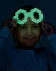 Girl wearing glow-in-the-dark toy glasses