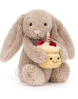 Beige bunny holding birthday cupcake