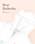 Close-up of personalised white Bear bathrobe embroidery detail on soft neutral background