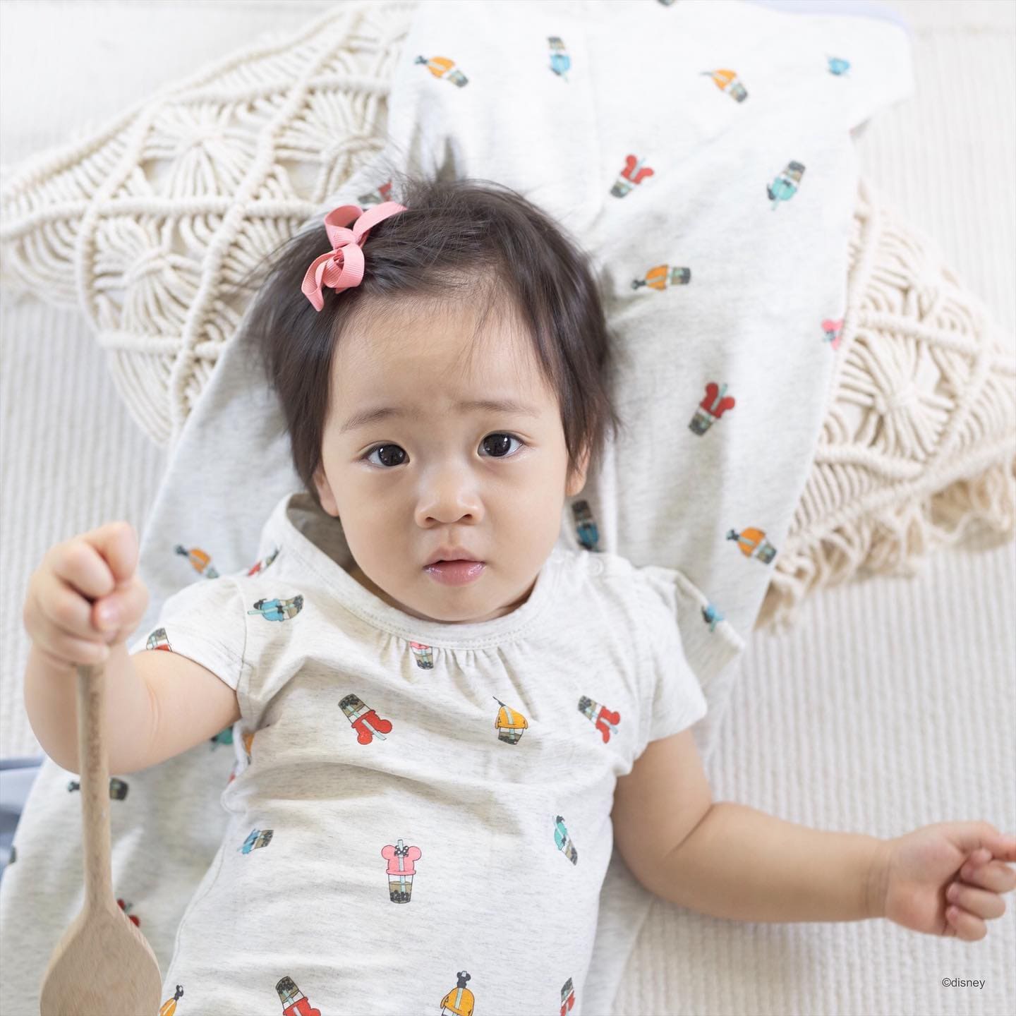 Baby with spoon, wrapped in blankets