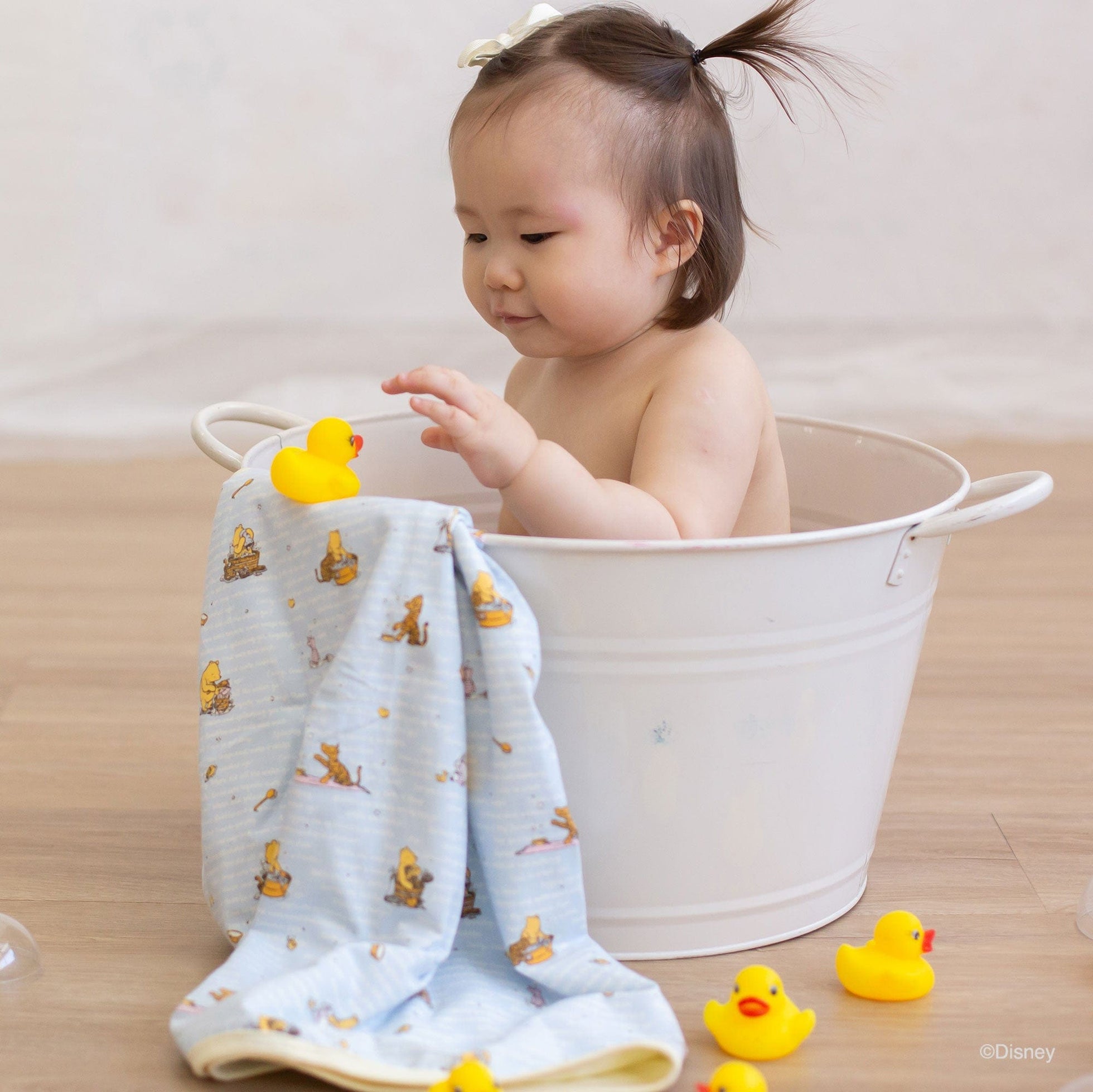 Baby in tub with blankets and rubber ducks