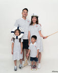 Family of four wearing matching sailor mickey stripes outfits with a white background