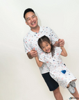 Man and young girl wearing matching nautical mickey outfits against a white background