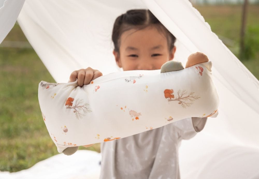 Child holding a decorative pillow from the collection