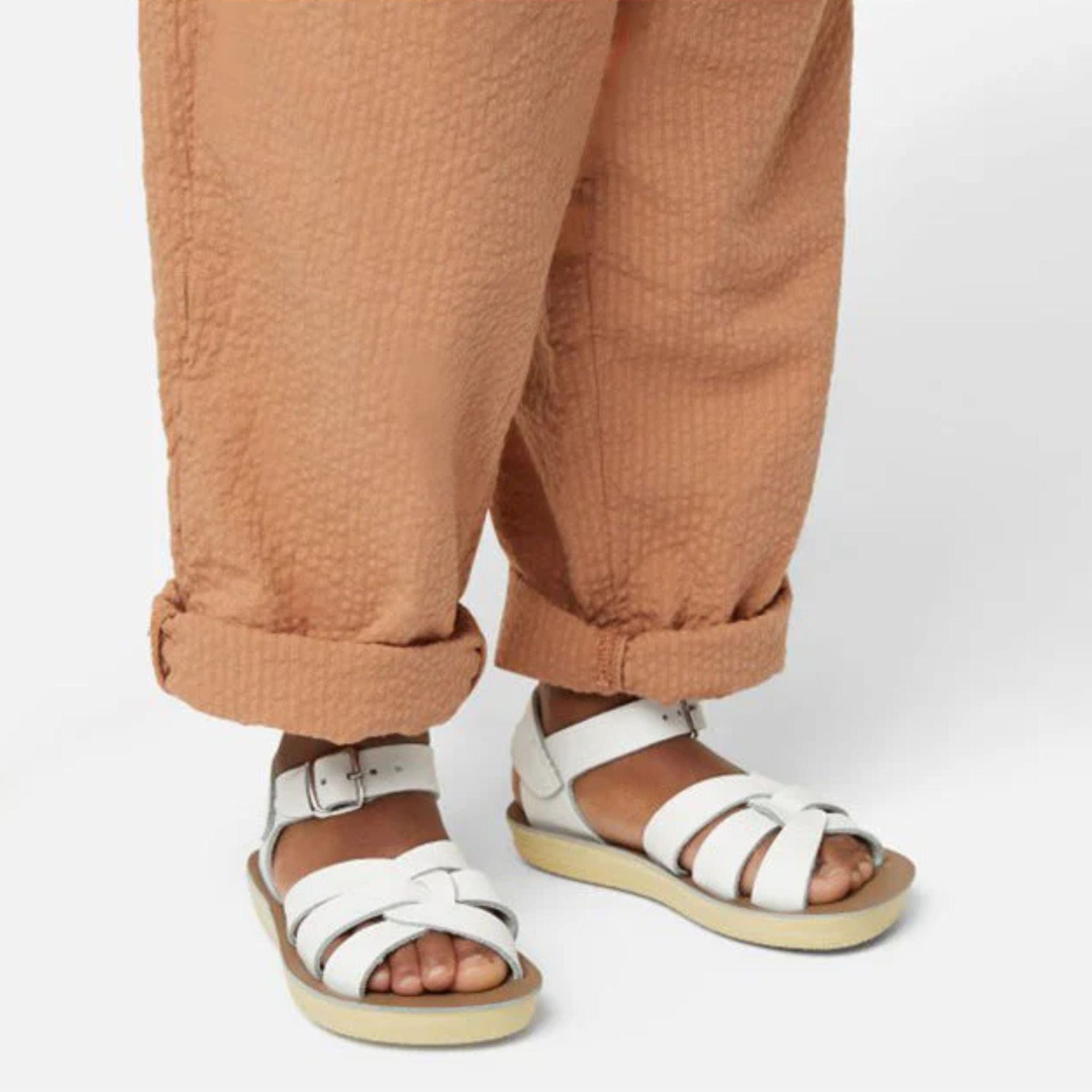 White kids sandals on feet