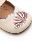 Angled view of a pair of Tip Toey Joey Seashell Mary Janes in White Dream / Rose Gold / Metal Blue