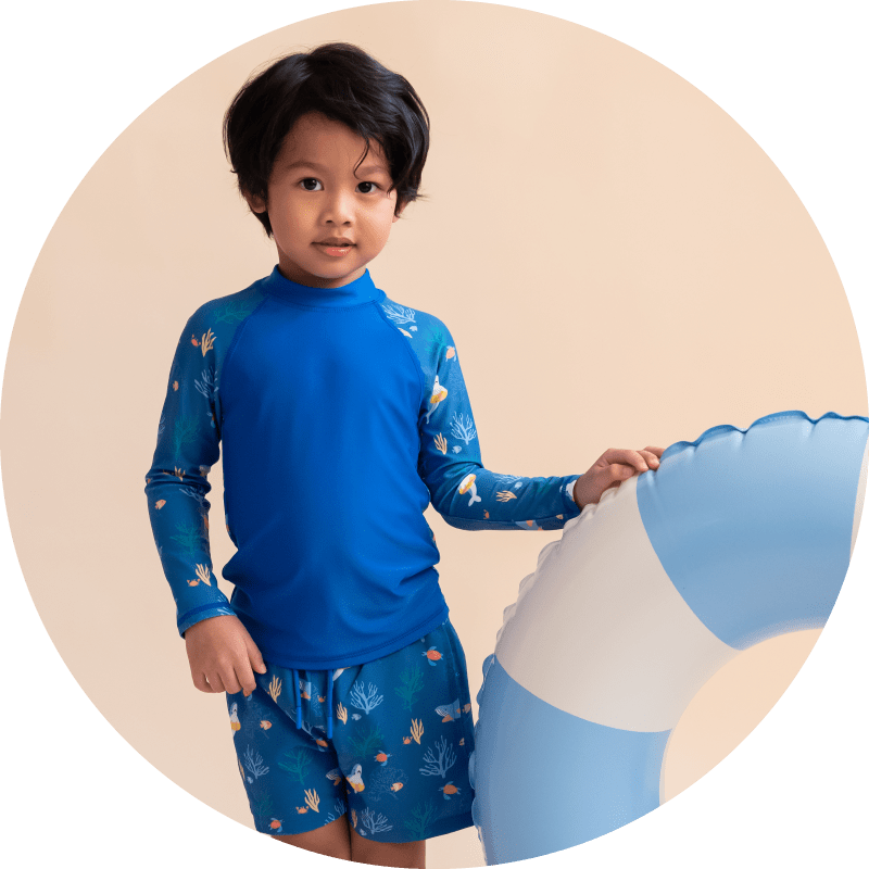 Boy in swim shirt and shorts with float