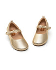 A pair of metallic gold leather Brigitte kids shoes angled to show the soft leather finish and comfortable lining.