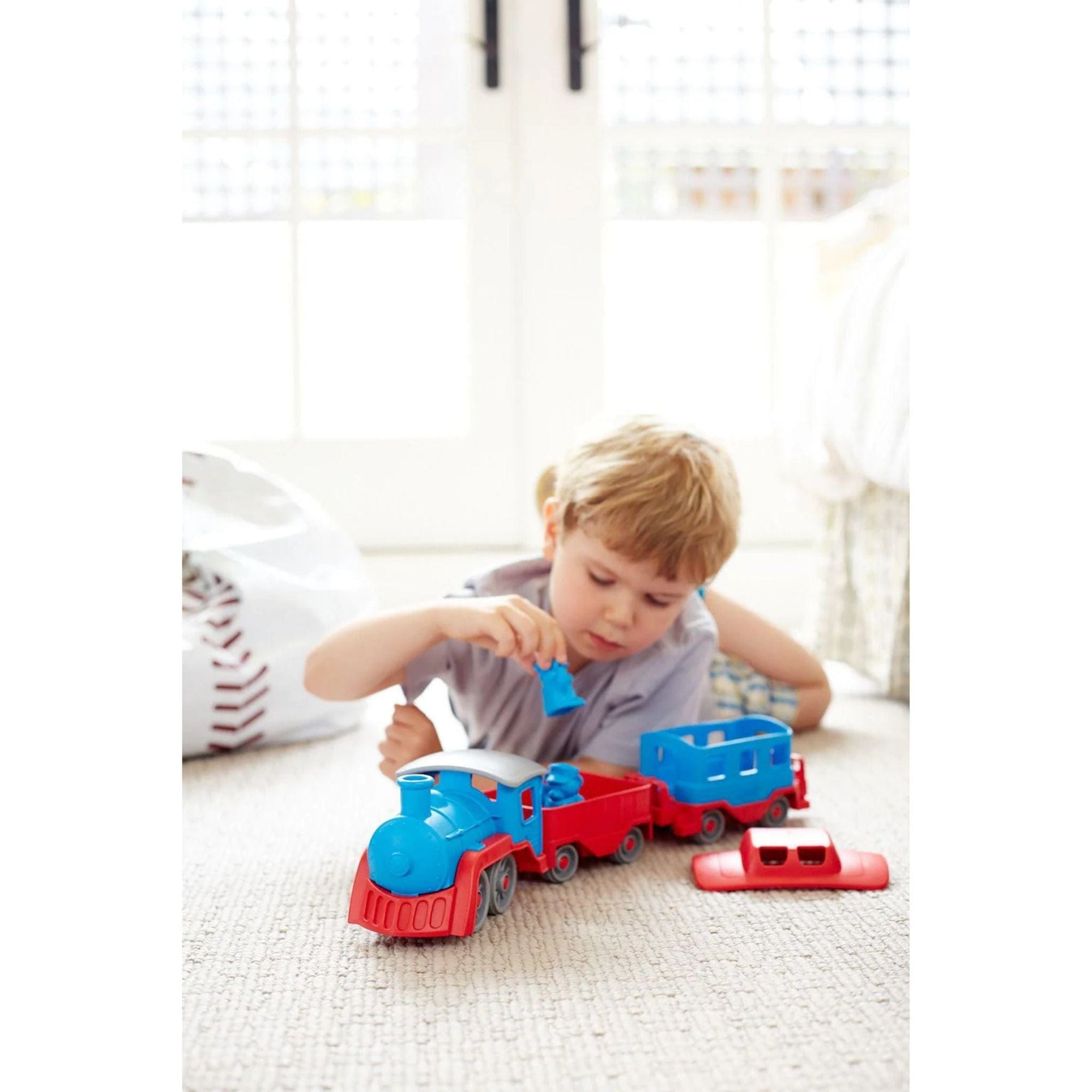 Boy playing with blue toy train