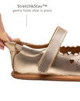 Close-up of the Stretch & Stay elastic heel on the metallic salmon baby shoe for a secure and comfortable fit.
