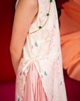 Girl wearing a sleeveless patterned dress with pink skirt.