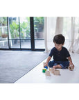 Child playing with PlanToys Geo Matching Blocks