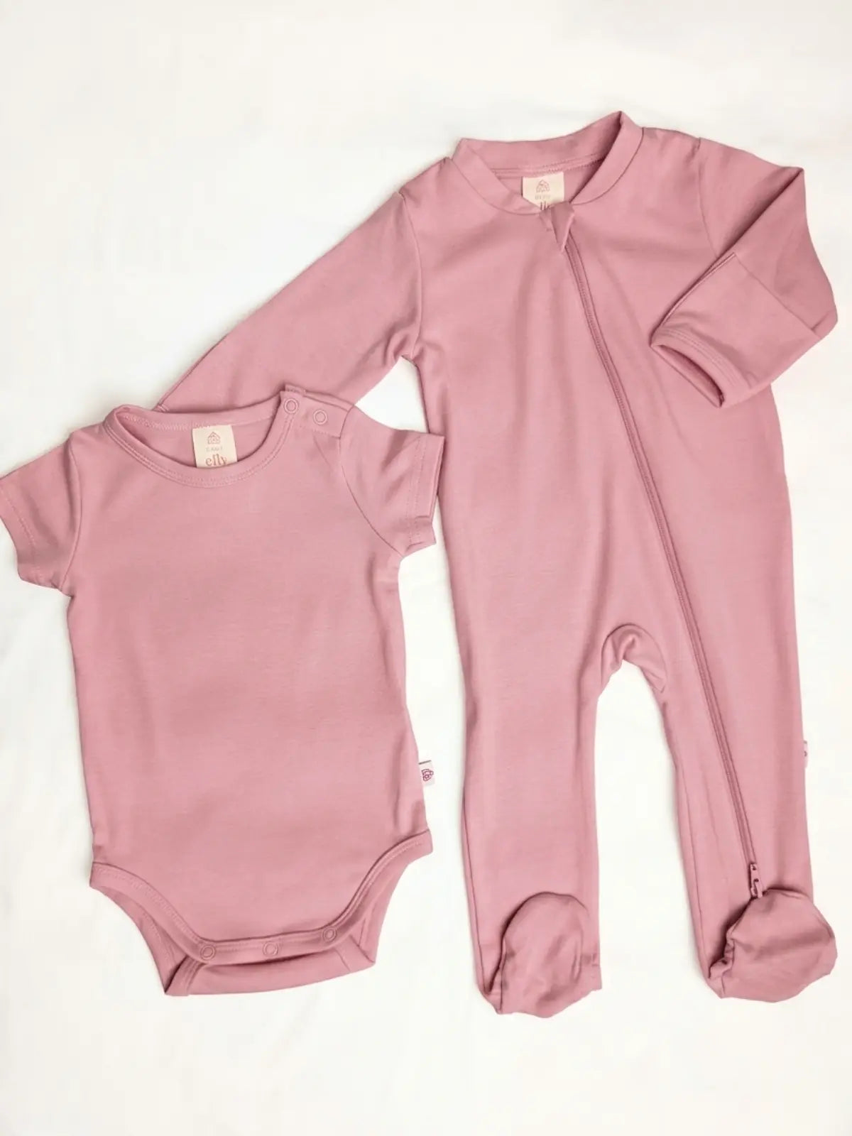 Pink baby onesie and bodysuit on a white background