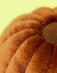 Close-up of a textured brown fabric with a yellowish-green background