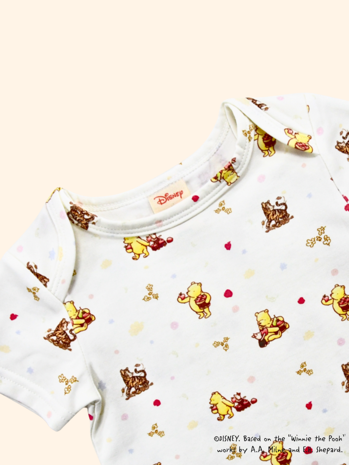 Close-up of white baby tee with Classic Pooh print, soft cotton fabric and gentle neckline