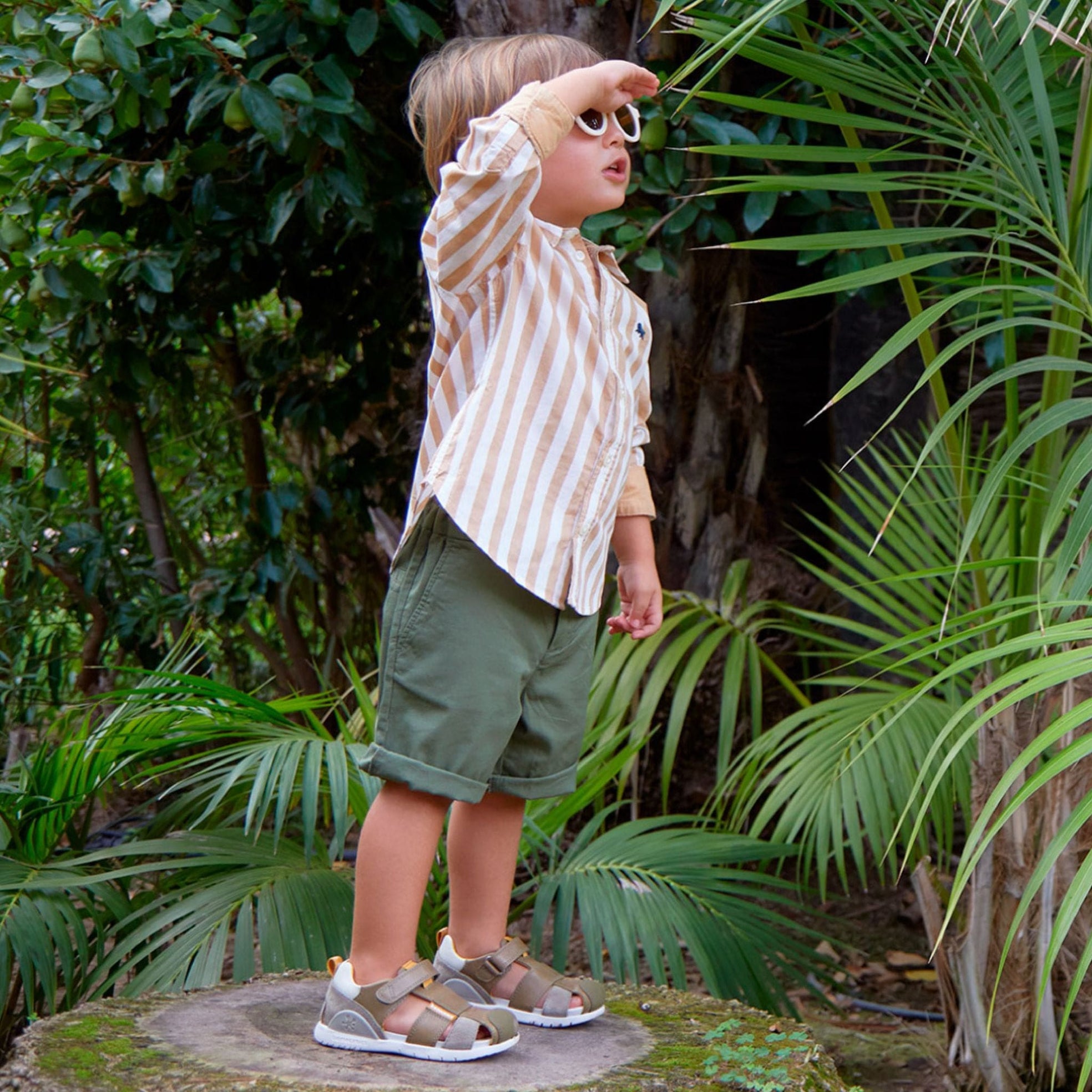 Biomecanics sandal-wearing boy in the jungle