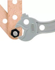 A close-up of a light gray Brio adjustable wrench tool with a hexagonal bit inserted, positioned over a wooden board on a white background.