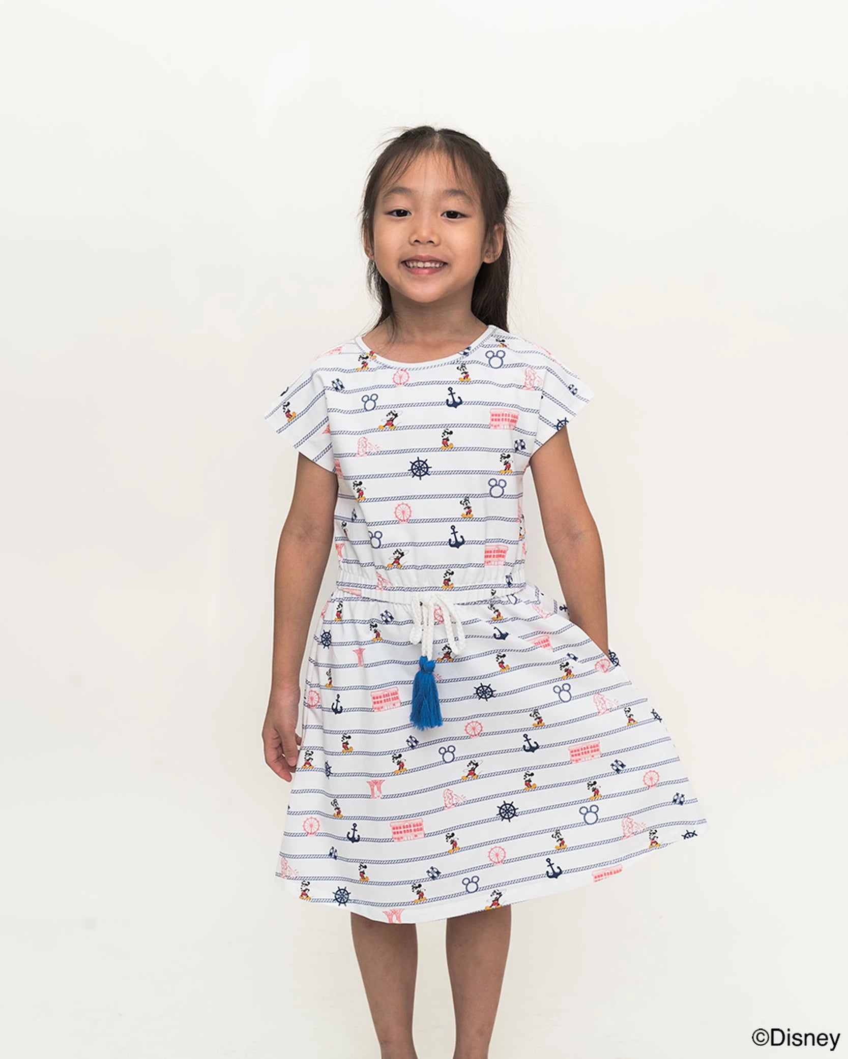Young girl wearing a hailey dress in nautical mickey on a white background