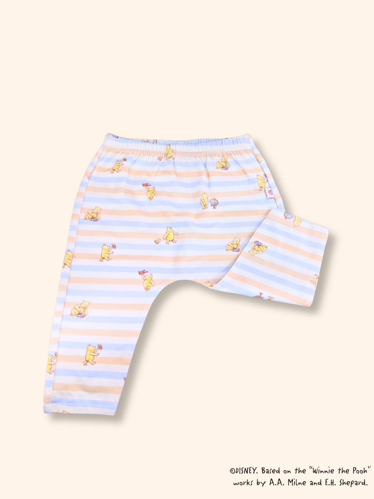 Close-up of baby leggings with blue striped Pooh print, soft stretch fabric and elastic waistband