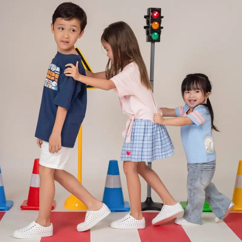 Three children playing near traffic cones with 'Zootopia' branding above them.