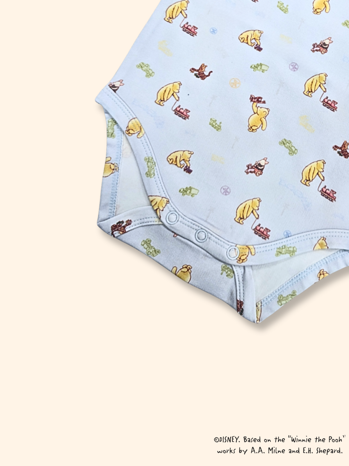 Classic Pooh baby onesie snap buttons for easy diaper changes, soft cotton fabric detail