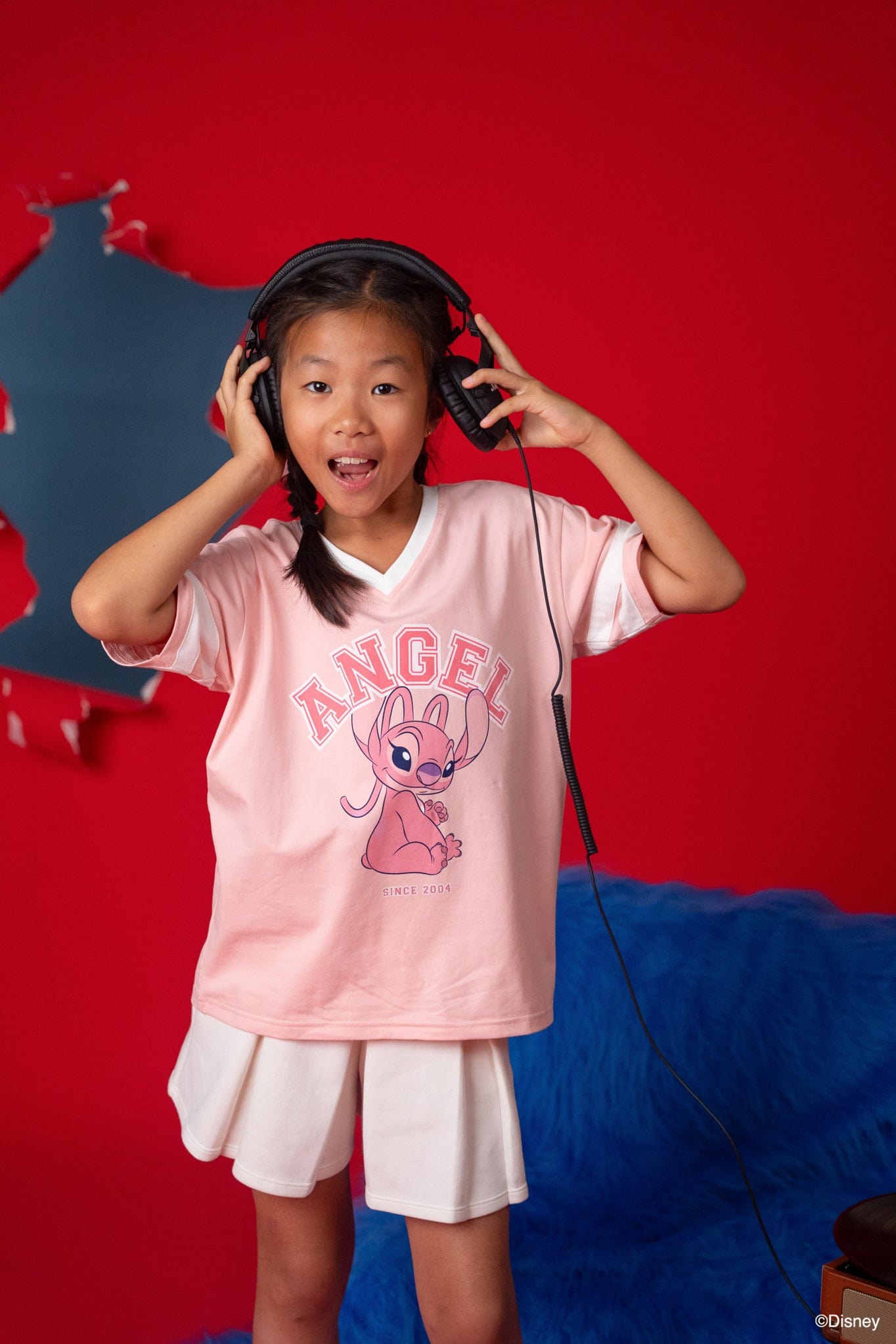 Girl in Stitch Angel tee shirt with headphones