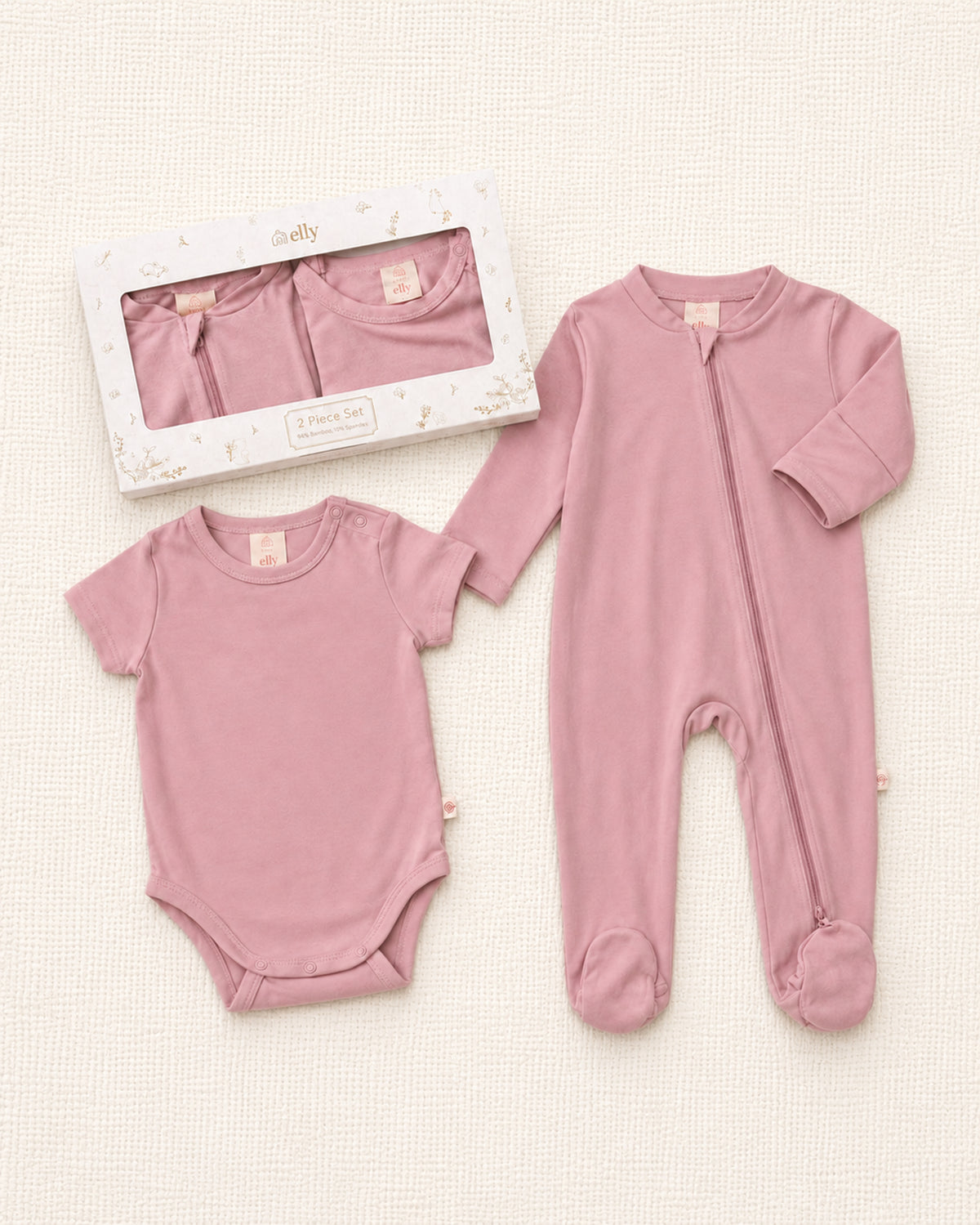 Pink baby bodysuit and onesie set on a light background