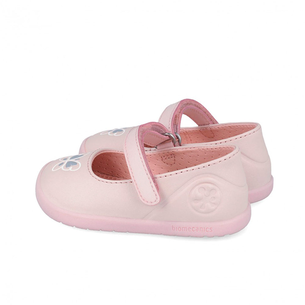 Pair of pink children's shoes with a strap on a white background