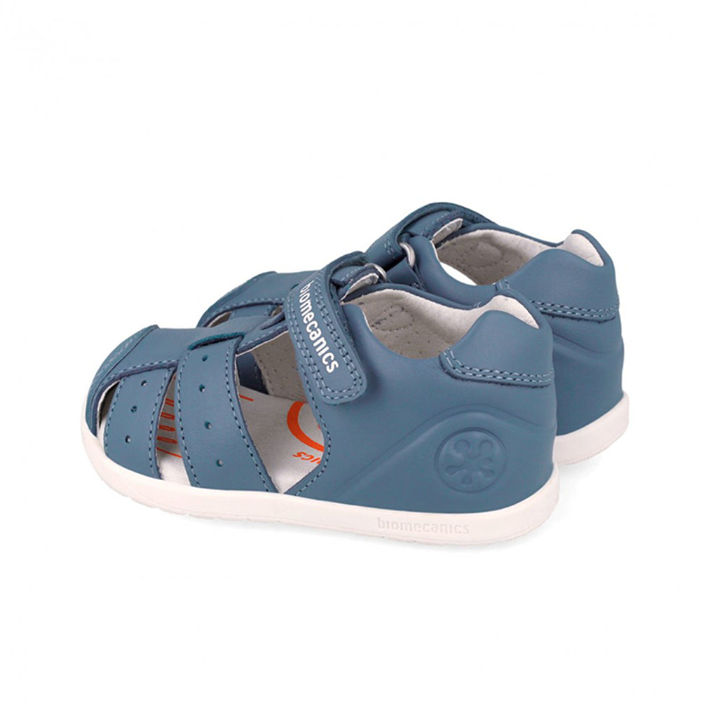 Blue children's sandal with white sole on a white background
