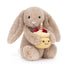 Beige bunny holding birthday cupcake