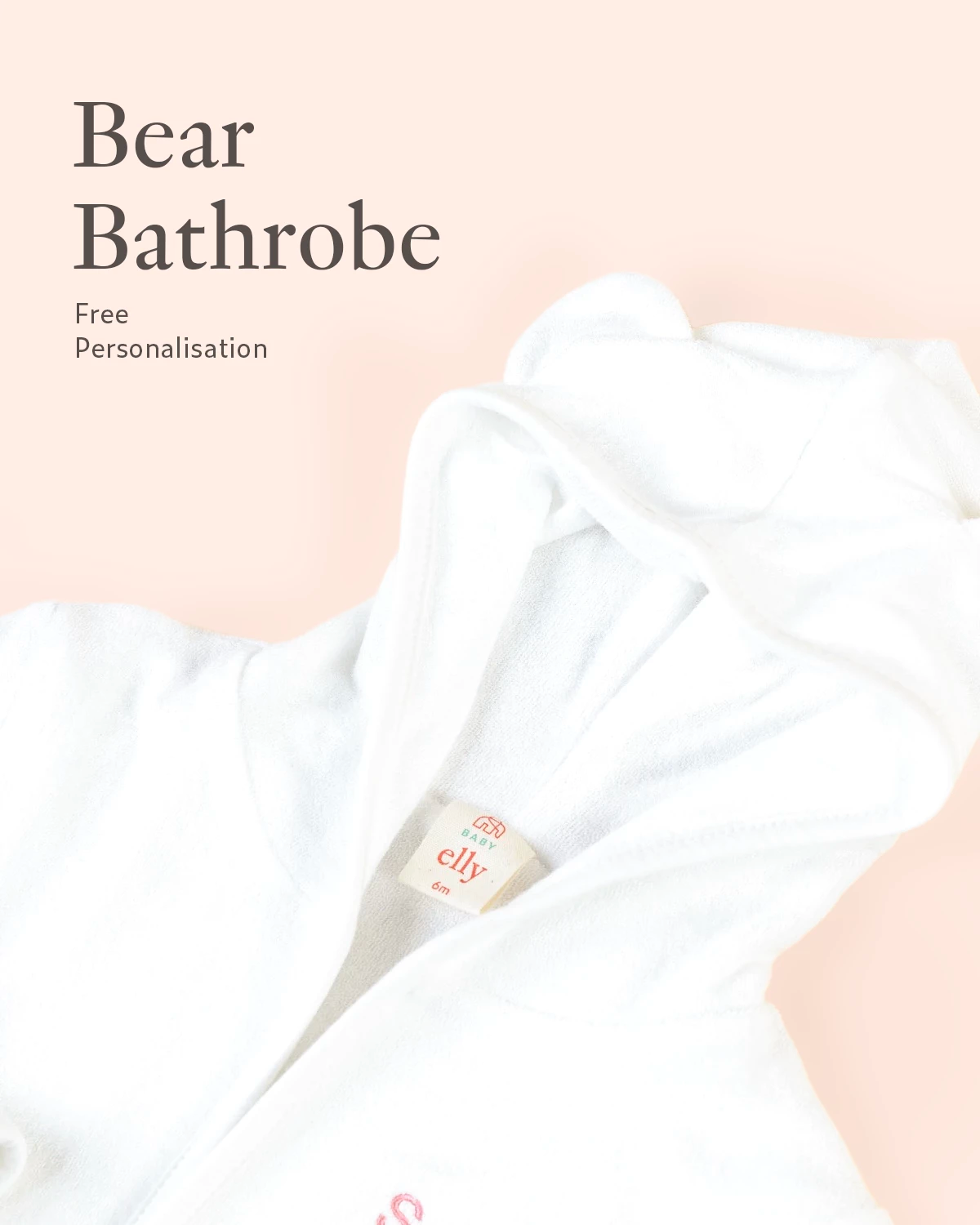 Close-up of personalised white Bear bathrobe embroidery detail on soft neutral background