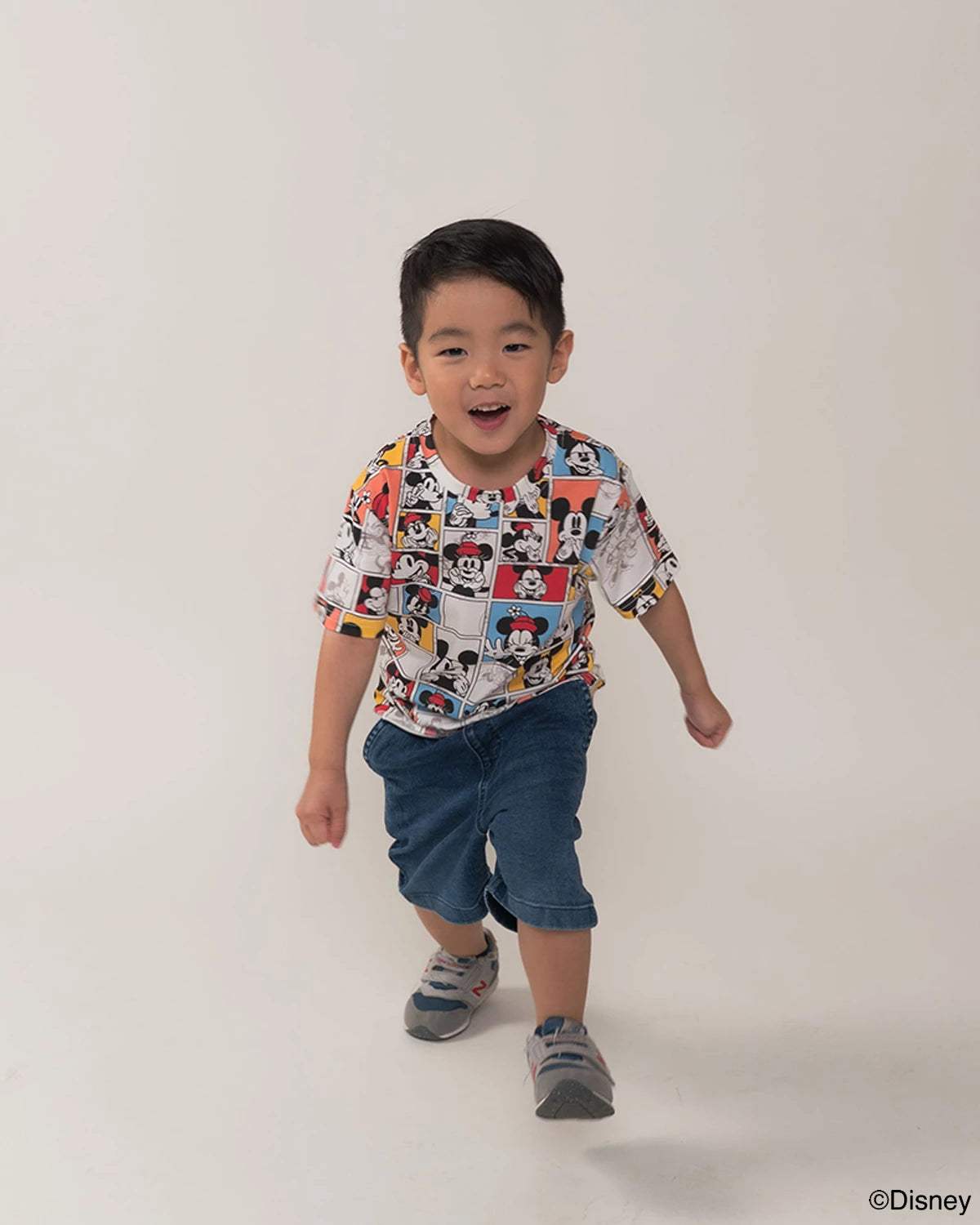 Child wearing pop comic mickey tee on a white background