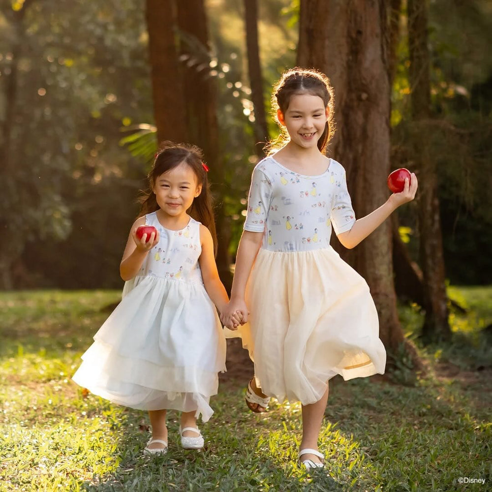 Disney Princess-themed girls holding apples in a forest