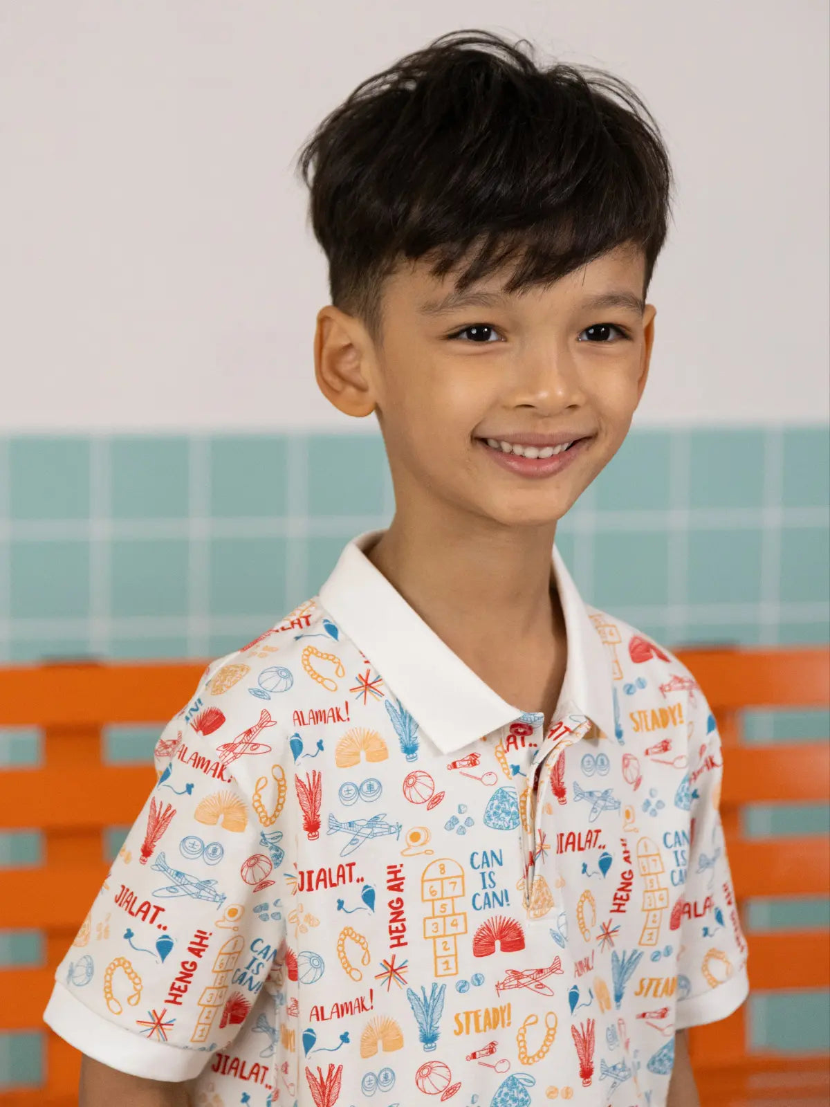 Side profile of boy wearing the Elly Childhood Games printed polo shirt.