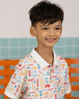 Side profile of boy wearing the Elly Childhood Games printed polo shirt.