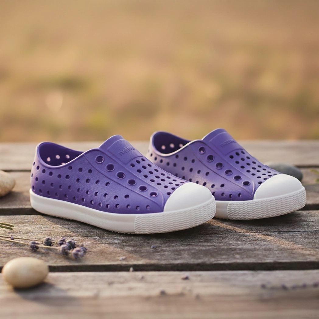 Purple native kids shoes with white soles on a wooden surface