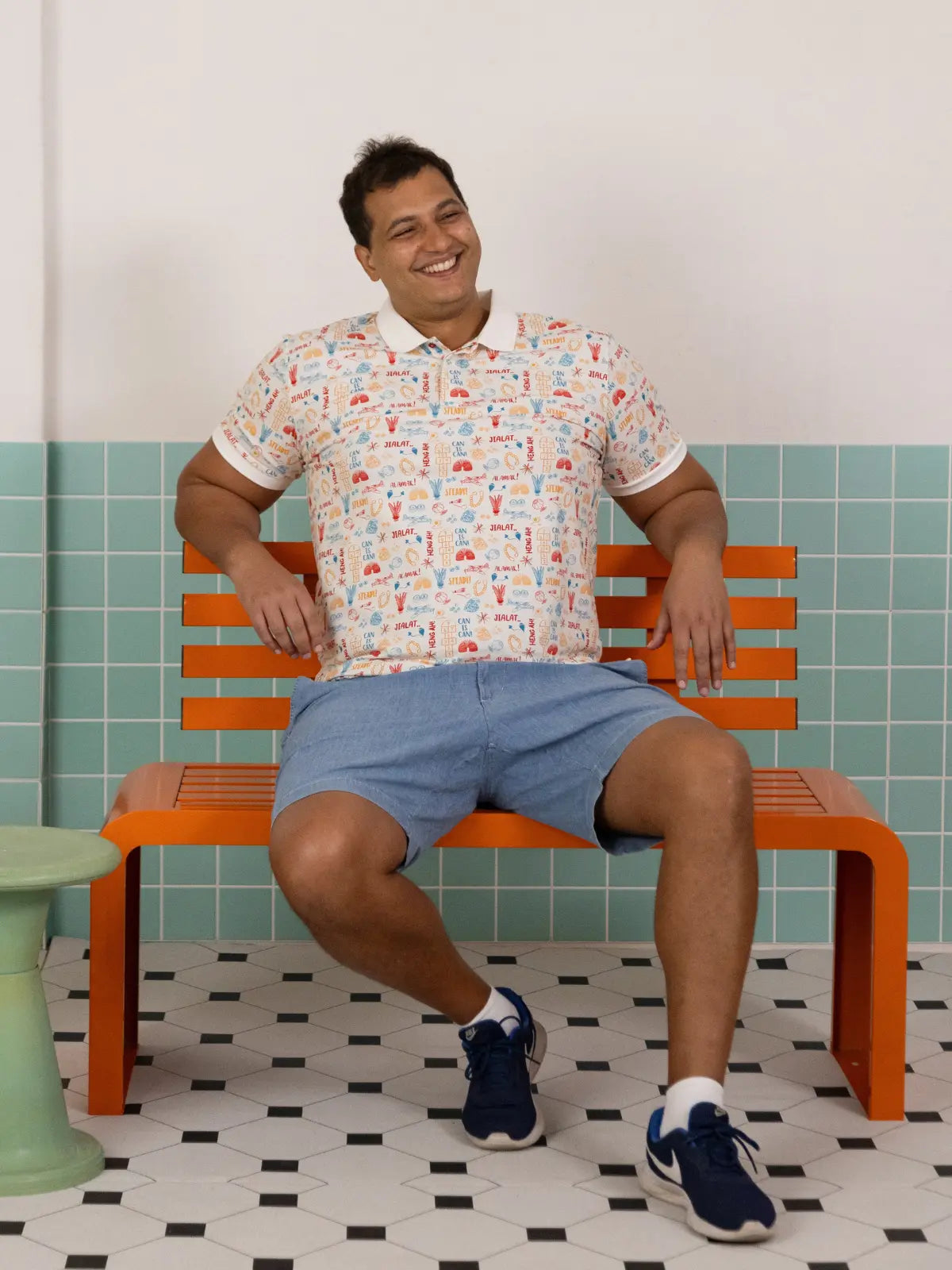 Full body shot of the Elly Men's Childhood Games Polo Tee with blue shorts.