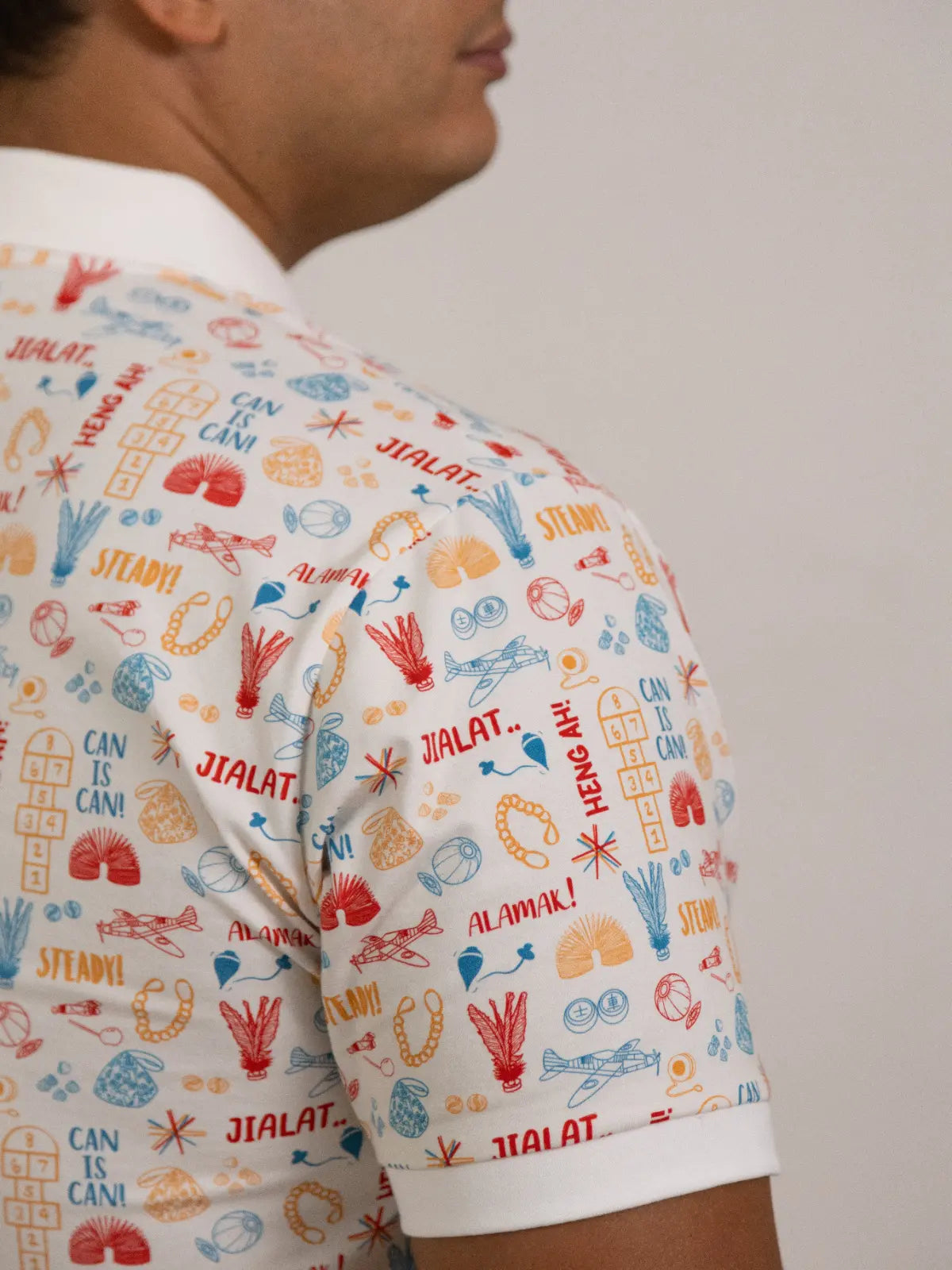 Side profile and sleeve detail of the Men's Childhood Games Polo by Elly.