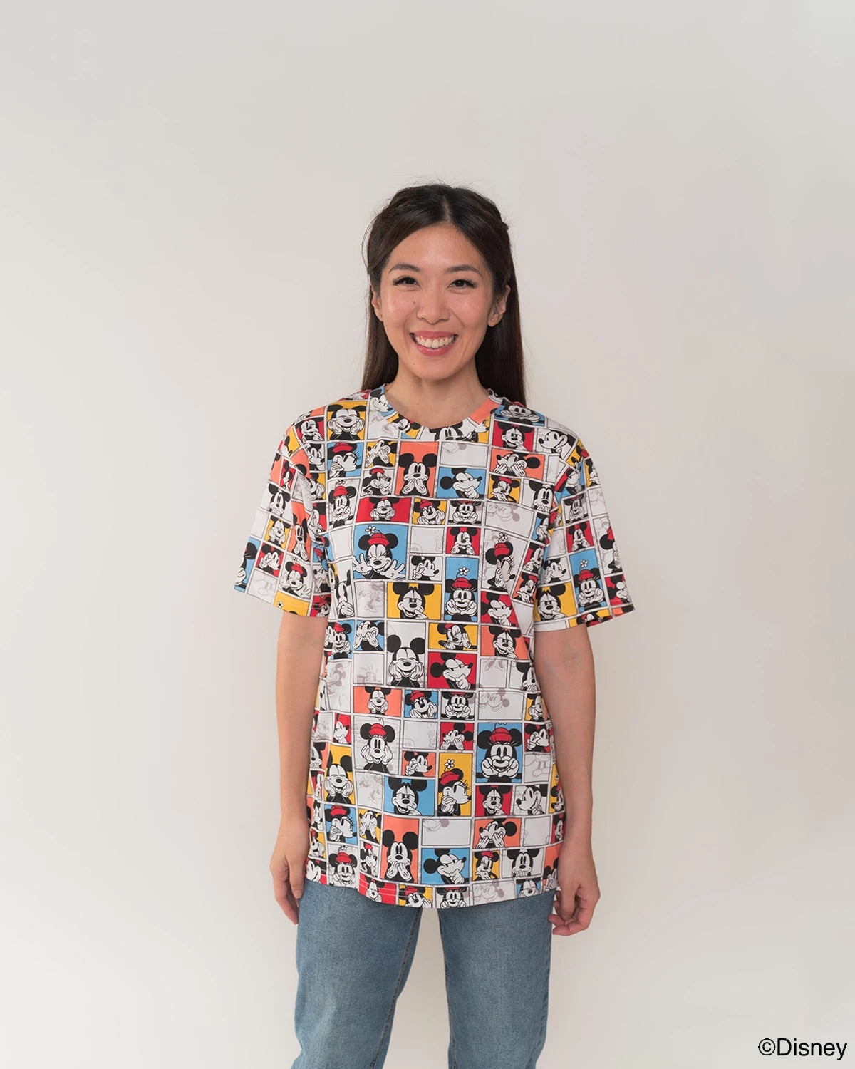 Woman wearing adult tee in pop comic mickey design with a plain background