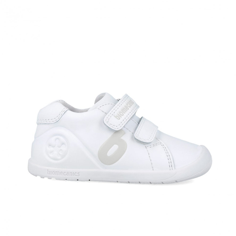 White children's shoe with velcro straps on a white background
