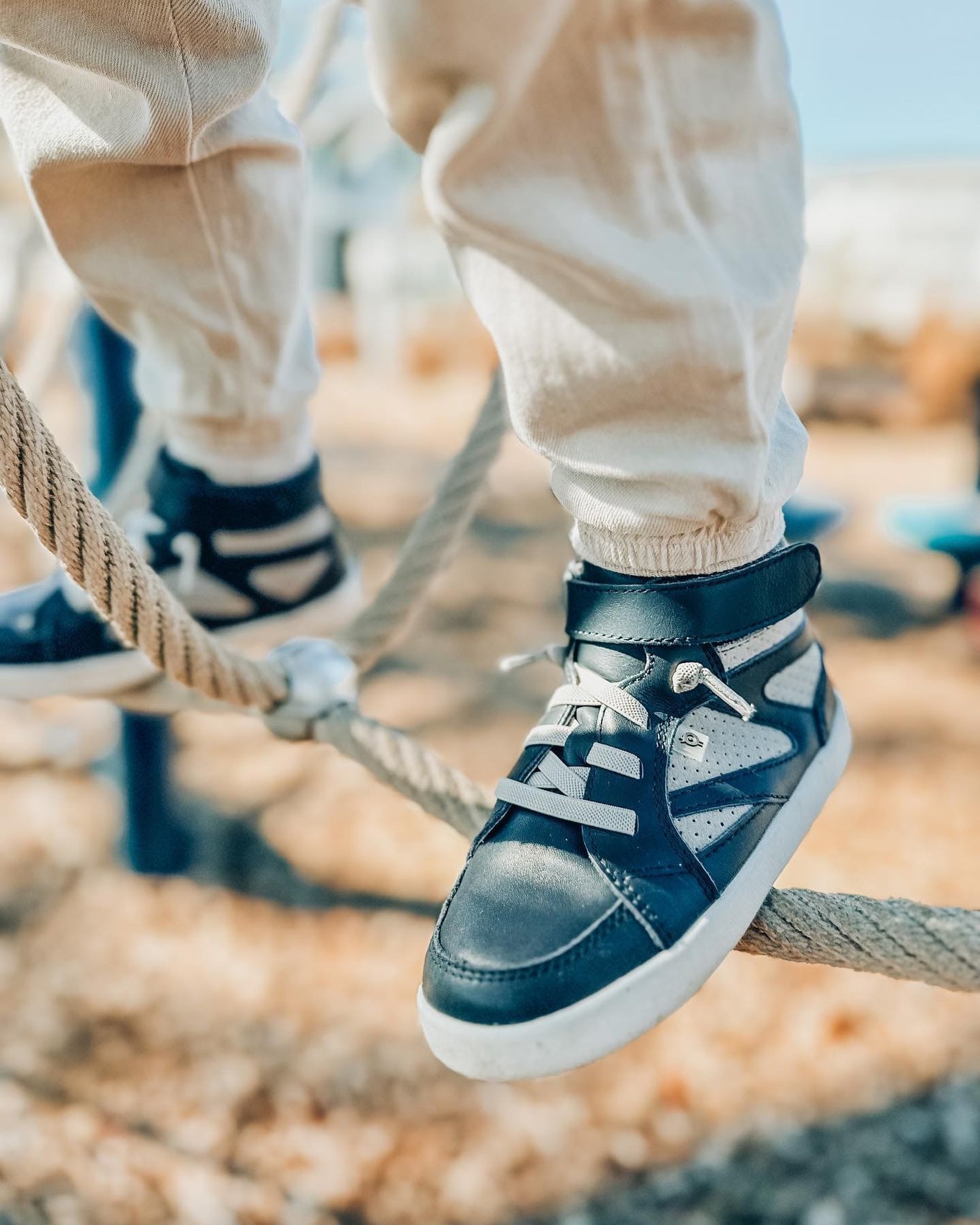 Boy's navy high-top sneakers on rope