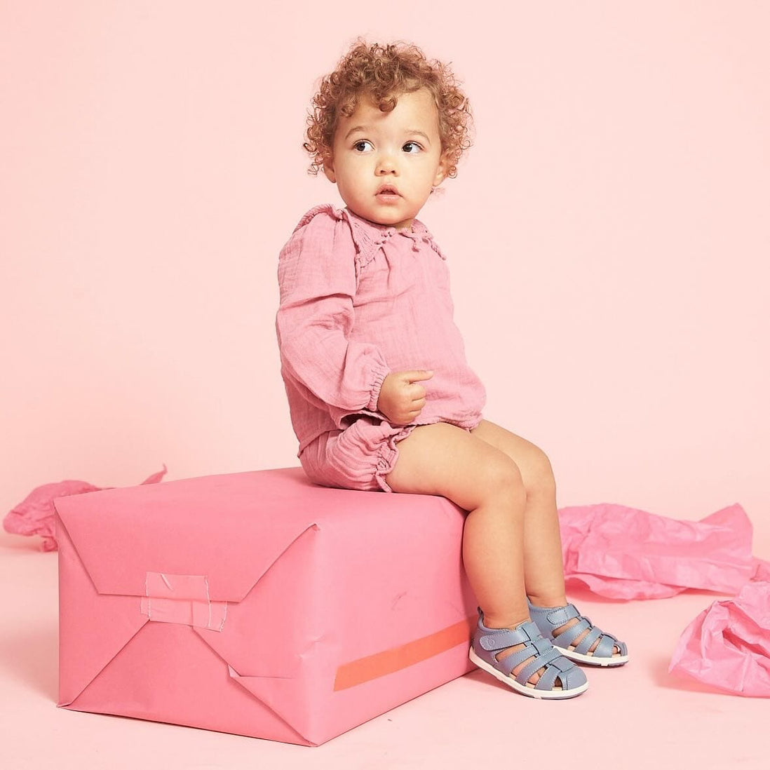 toddler in pink outfit and sandals