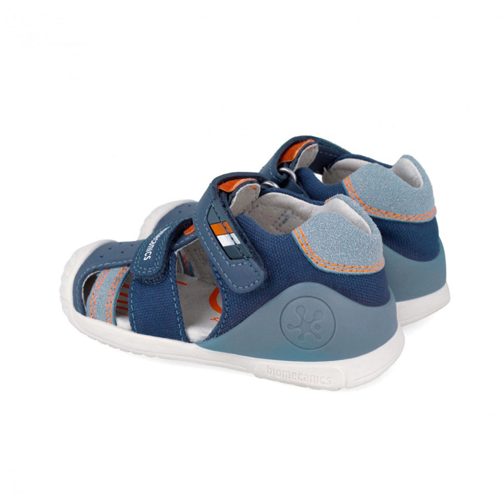 Blue children's sandal with orange accent and white sole on a white background