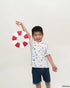 Child wearing nautical mickey polo tee holding a red and white life buoy against a plain background