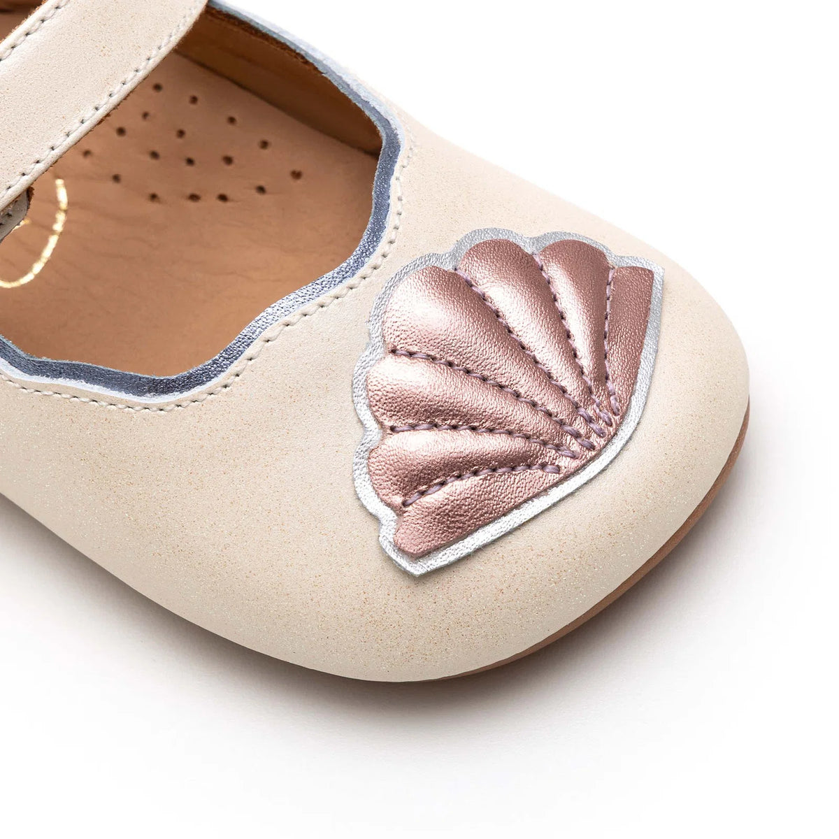 Angled view of a pair of Tip Toey Joey Seashell Mary Janes in White Dream / Rose Gold / Metal Blue