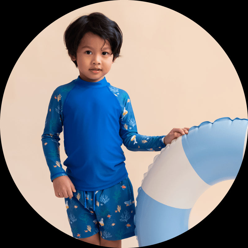 Boy in swim shirt and shorts with float