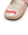 Close-up of the cupcake applique on the toe of the shoe, showing layered leather details in pink, mint green, and gold.